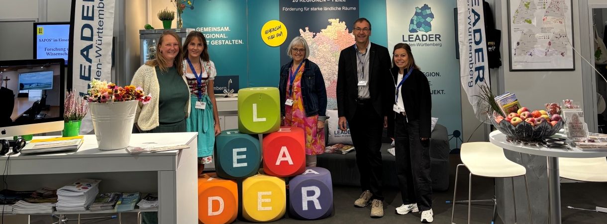 Fünf Personen am LEADER-Stand auf dem LWH. Aufsteller im Hintergrund.