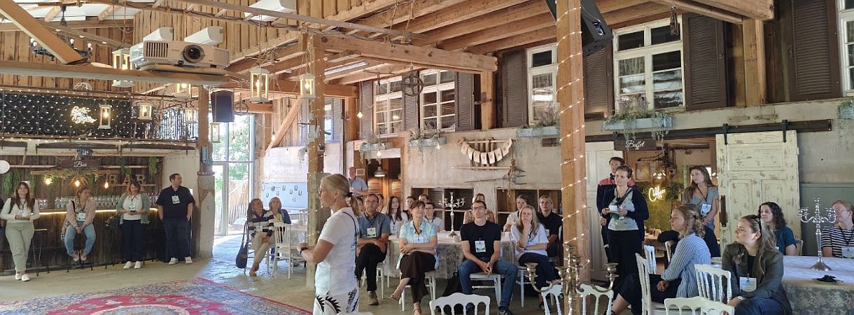 Eventscheune von innen mit Dekoration, Tischen und Menschen