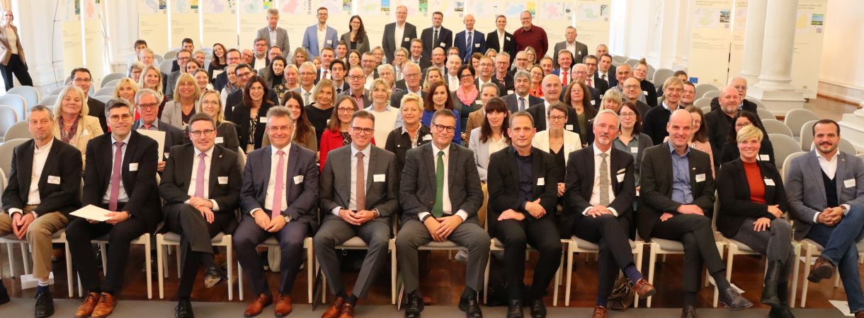 Gruppenbild: Vertreter der LEADER-Aktionsgruppen und des Landes sitzen in Stuhlreihen  im weißen Saal des neuen Schlosses Stuttgart bei der Urkundenübergabe für die Förderperiode 2023-2027